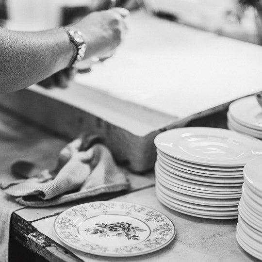 Hands of woman placing decals onto bone china plates