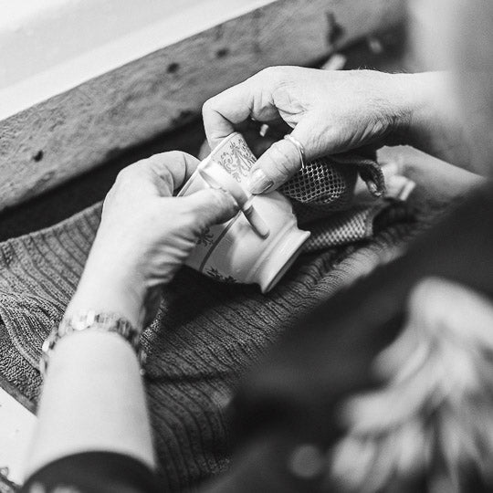 Hands of woman placing decal onto bone china cup